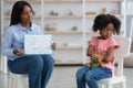 Little african american girl avoiding female child psychologist Royalty Free Stock Photo