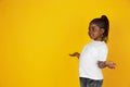 Little african-american girl`s portrait isolated on yellow studio background Royalty Free Stock Photo