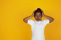 Little african-american girl`s portrait isolated on yellow studio background Royalty Free Stock Photo