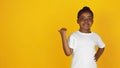 Little african-american girl`s portrait isolated on yellow studio background Royalty Free Stock Photo