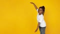 Little african-american girl`s portrait isolated on yellow studio background Royalty Free Stock Photo