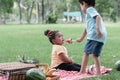 Little kids picnic and playing in the park. Little cute girl crying and boy consoling friend with giving her a piece of watermelon