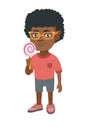 Little african boy holding a lollipop candy.