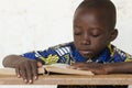Little African Boy Reading Big Book at School with copy space Royalty Free Stock Photo