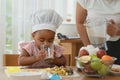 Little African child girl and mother making healthy fruits smoothie with blender together from banana, apple and milk in kitchen Royalty Free Stock Photo