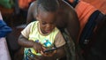 Little African cute toddler plays the phone