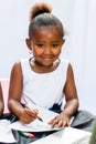 Little African girl drawing with crayons. Royalty Free Stock Photo