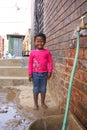 Little African Girl getting splashed by hosepipe water in a Soweto Township back yard Royalty Free Stock Photo