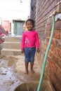 Little African Girl getting splashed by hosepipe water in a Soweto Township back yard Royalty Free Stock Photo