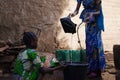 Little African Girls Collecting Water from a Well