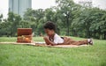 Little African kid boy crying and holding a sore finger when playing xylophone toys alone with sad face at park and lying down Royalty Free Stock Photo