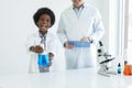 Little African kid learning chemistry and doing a chemical science experiment in a laboratory in school