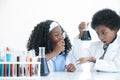 Little African kids learning chemistry and doing chemical science experiment in laboratory at school. Excited dark skinned boy and Royalty Free Stock Photo