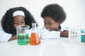 Little African kids learning chemistry and doing a chemical science experiment in a laboratory in school Royalty Free Stock Photo