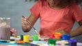 Little Afro-American girl painting a picture at art club, preschool education