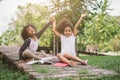 Little Afro child girl reading book between green spikes meadow garden with friend Royalty Free Stock Photo