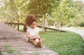 Little Afro child girl reading book between green spikes meadow garden. Royalty Free Stock Photo