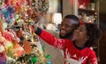 Little afro girl helping daddy to decorate family Christmas tree