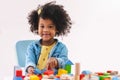 Little afro girl smiling and playing colorful wooden toys