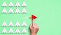 Little airplanes and a hand pointing to a red one symbolizing a different approach