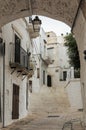 Little alley in the medieval white village of Ostuni at sunset