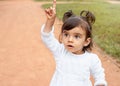 Little amazed baby girl pointing finger up in the park Royalty Free Stock Photo