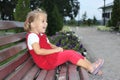 The little amusing girl on a bench in park
