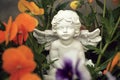 Little angel and pansy flowers Royalty Free Stock Photo