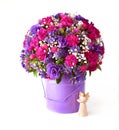 A little angel next to a bucket full of beautiful pink and purple flowers for Christmas greetings Royalty Free Stock Photo