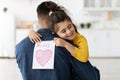 Little arab girl embracing daddy and holding greeting card for Fathers Day Royalty Free Stock Photo