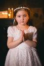 Little armenian redhead girl in ancient armenian monastery praying and looking at camera in front of candles Royalty Free Stock Photo