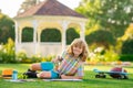 Little artist drawing painting art in park. Child artist, kids crafts. School kids drawing in summer park, painting art Royalty Free Stock Photo