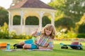 Little artist drawing painting art in park. Child drawing picture with crayon in summer park outdoor. Happy little kid Royalty Free Stock Photo