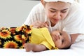 A little Asian African newborn baby girl lying on white bed with mother holding her hand, mother showing love and care to new Royalty Free Stock Photo