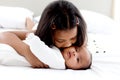 A little Asian African newborn infant baby girl lying on white bed with her sister who hugging and kissing her, sweet adorable kid Royalty Free Stock Photo