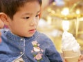 Little Asian baby being hungry for appealing ice cream cone in front of her Royalty Free Stock Photo