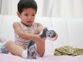 Little Asian baby being whiny while she is trying to put on socks Royalty Free Stock Photo