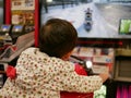 Little Asian baby enjoys riding an arcade motorcycle game Royalty Free Stock Photo