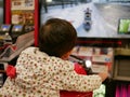 Little Asian baby enjoys riding an arcade motorcycle game