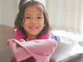 Little Asian baby girl being happy, with big smile, as she just successfully folded her own pants Royalty Free Stock Photo