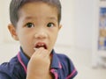 Little Asian baby girl eating fruit, pomelo, by herself Royalty Free Stock Photo