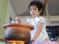 Little Asian baby girl enjoys cooking Thai-style hot pot Royalty Free Stock Photo