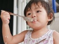 Little Asian baby girl enjoys eating food by herself Royalty Free Stock Photo