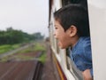 Little Asian baby girl enjoys shouting from a train window and having the wind whips against her face Royalty Free Stock Photo