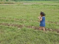 Little Asian baby girl enjoys walking in a field in a rural area Royalty Free Stock Photo