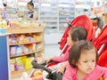 Little Asian baby girl front getting bored waiting for a long time in a baby stroller for her mother buying drugs a pharmacy Royalty Free Stock Photo