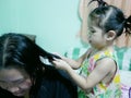Little Asian baby girl giving her aunty`s hairs done Royalty Free Stock Photo