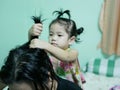 Little Asian baby girl giving her aunty`s hairs done