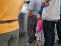 Little baby girl learning to wait patiently in a queue like any other adults, to weigh buying raw products and calculate prices