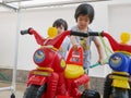 Little Asian baby girl learning to wash plastic big bikes while her little sister watching and standing nearby